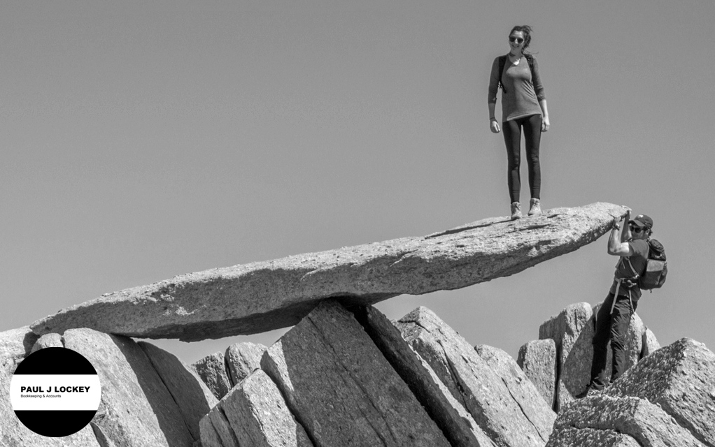 Work-life balance: two people playing on the Glyder Fach Cantilever Stone in Snowdonia, North Wales.